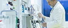 senior male researcher carrying out scientific research in a lab using a gas chromatograph (shallow DOF; color toned image)